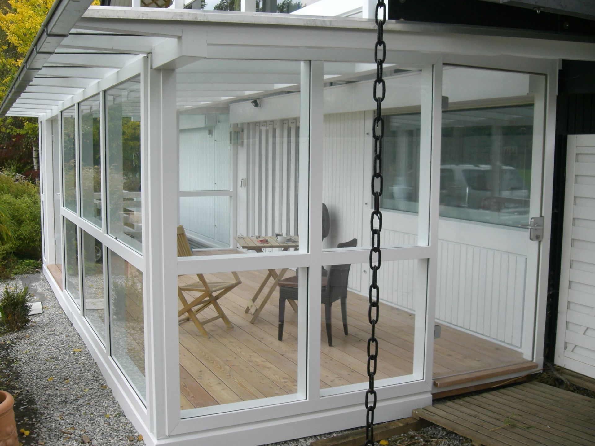 ein weißes Haus mit vielen Fenstern und einem Tisch und Stühlen darauf