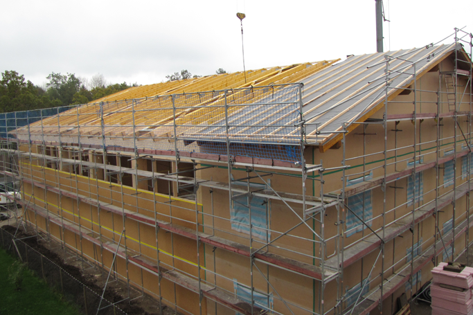 ein großes Gebäude, das mit Gerüst umgeben ist, während es gebaut wird