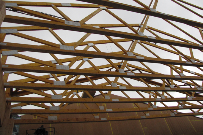 ein großes Gebäude mit einer Holzkonstruktion darauf