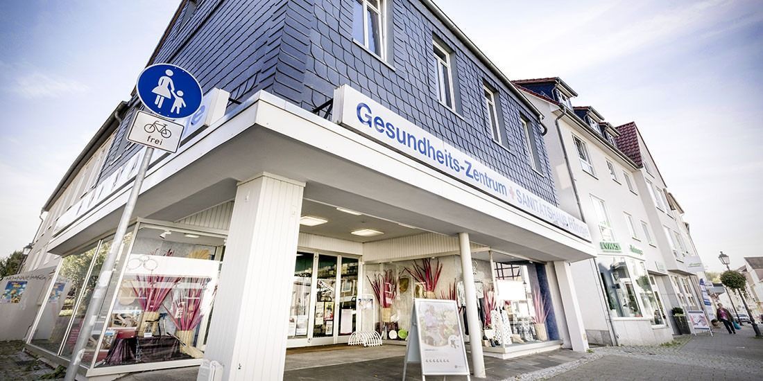 Gebäude mit Schild „Gesundheitszentrum“. Fußgängerüberweg-Schild sichtbar.