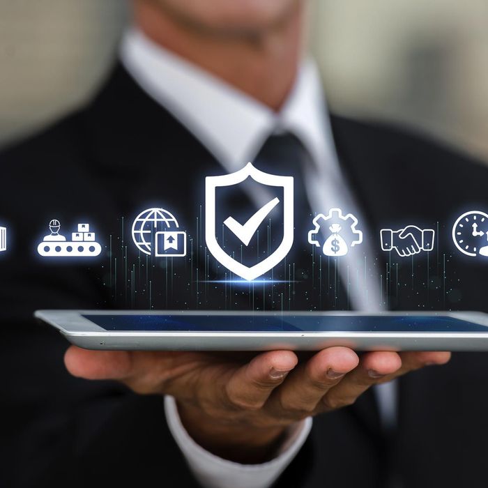 Empresario sosteniendo una tableta con iconos brillantes de ciberseguridad y nube flotando sobre ella.