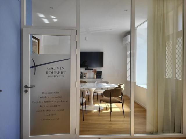 Intérieur d'un bâtiment avec une table blanche entourée de chaises marrons