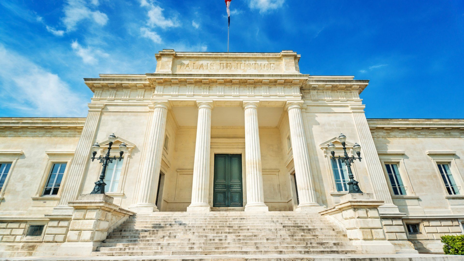 Devanture d'un palais de justice néoclassique avec des colonnes en pierres