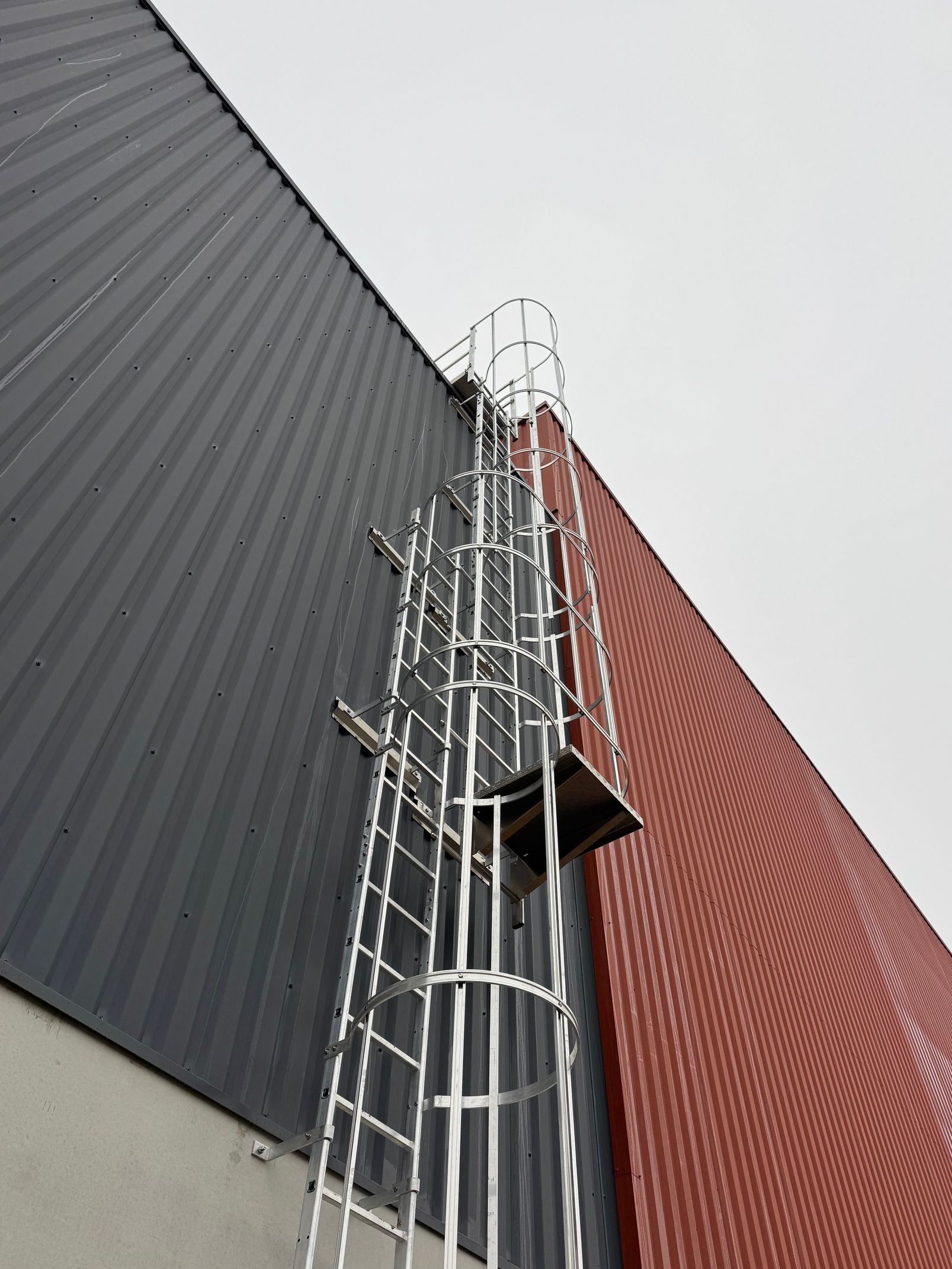 Échelle à crinoline sur un bâtiment orange et noir.