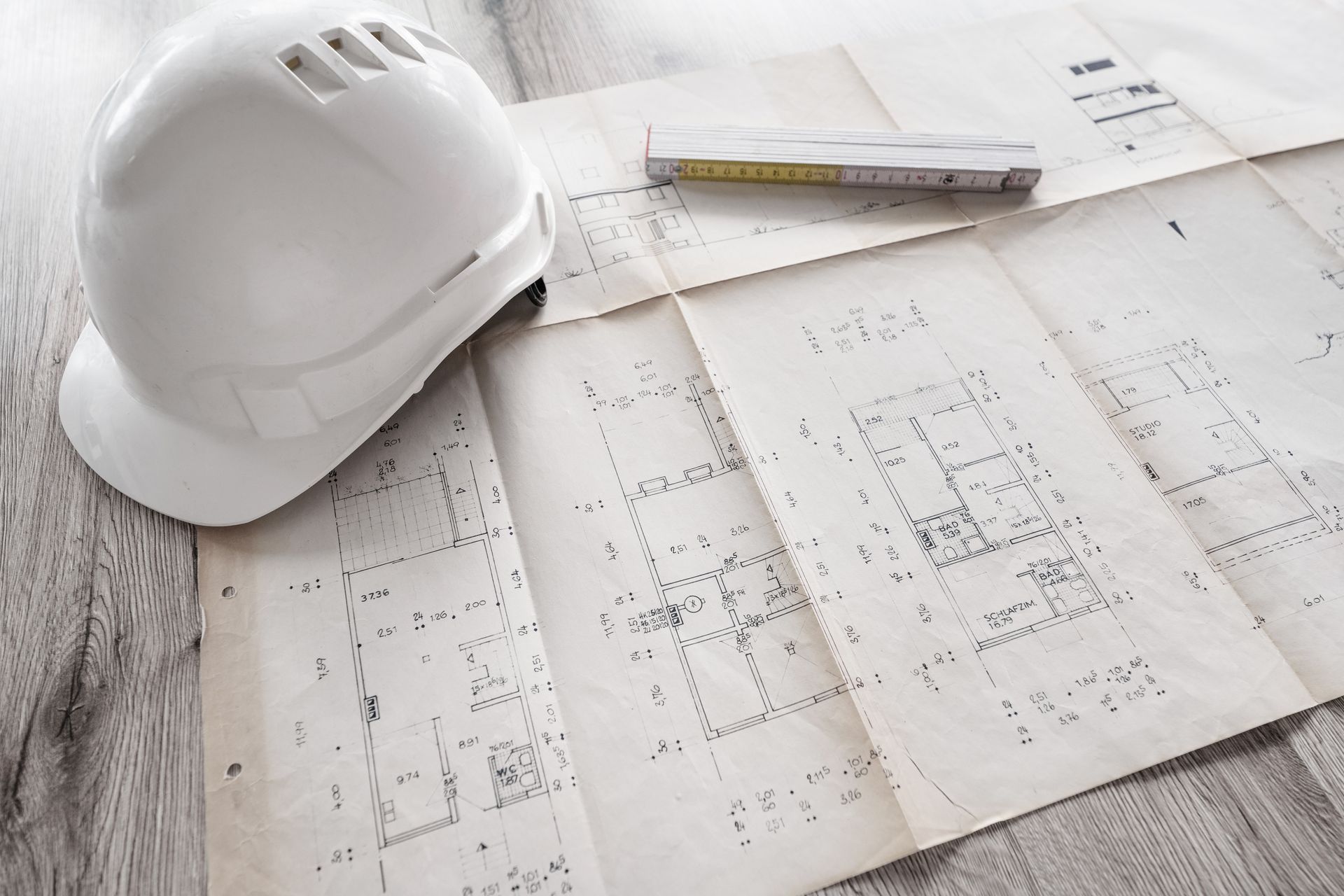 Casque blanc sur des plans techniques étalés sur un bureau