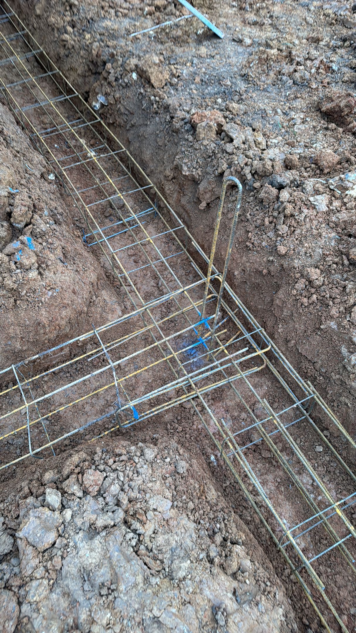 Grille d'armature en acier posée sur un terrain boueux sur un chantier de construction