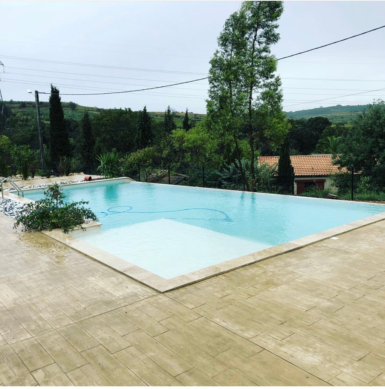Une terrasse en carrelage avec une piscine