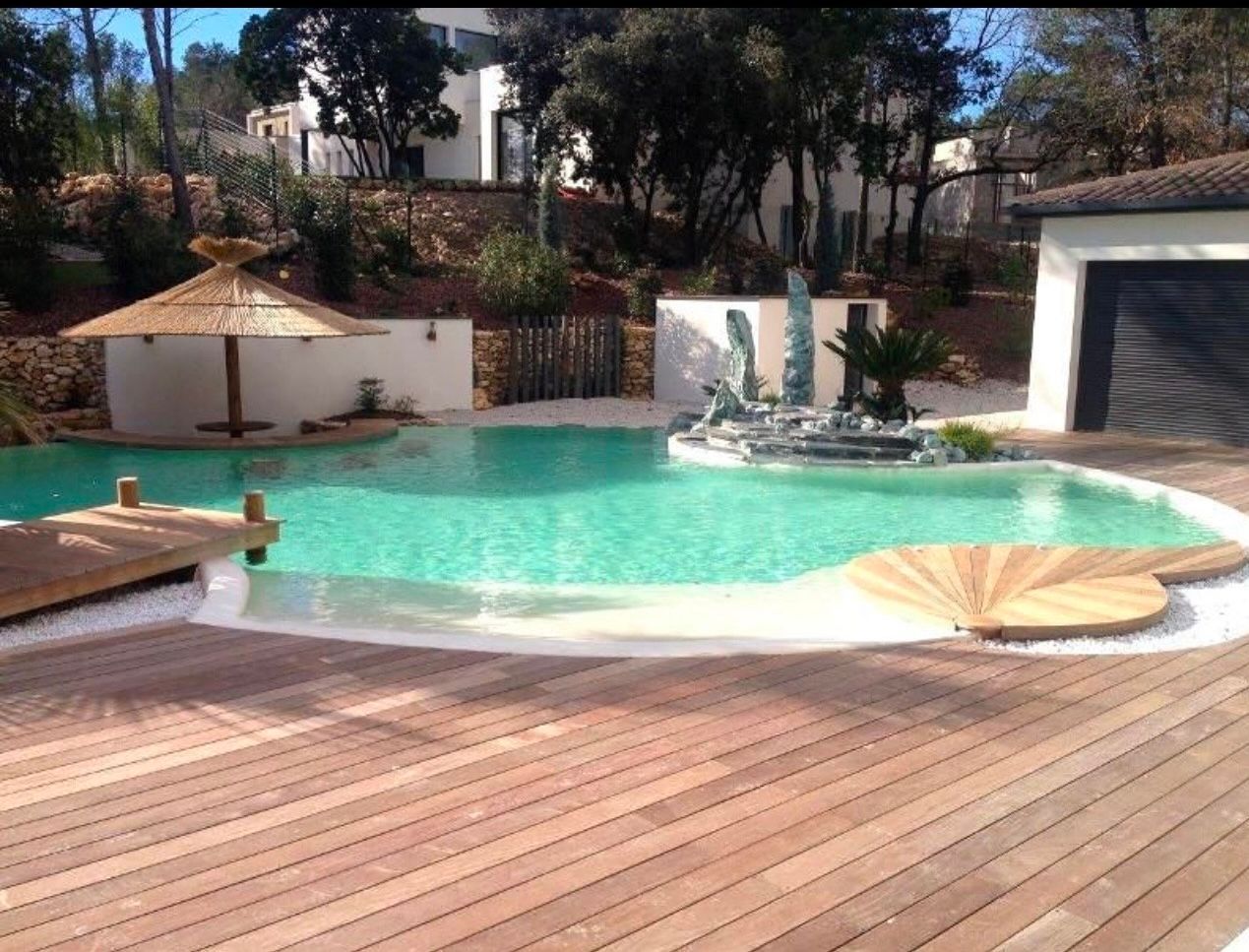 Une piscine arrondie avec une terrasse en bois