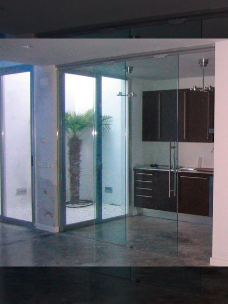 Una cocina moderna con puertas de vidrio, una isla gris y piso de madera.