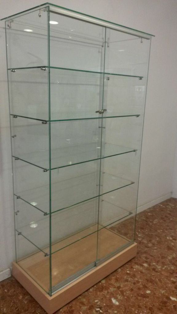 Vitrina de cristal con base de madera y múltiples estantes.