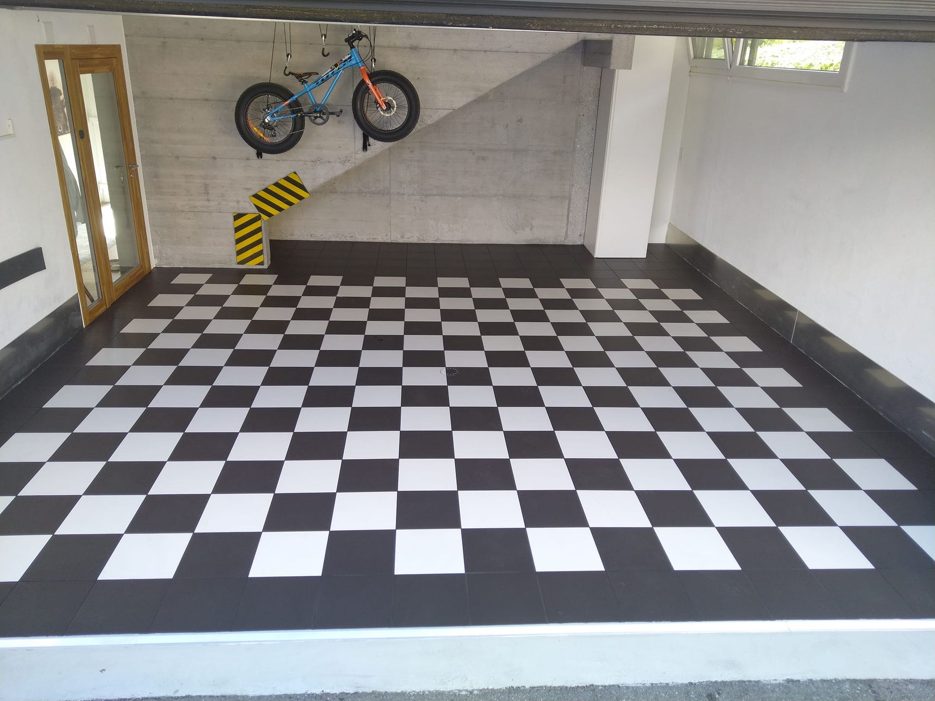 garage vide avec carrelage noir et blanc au sol