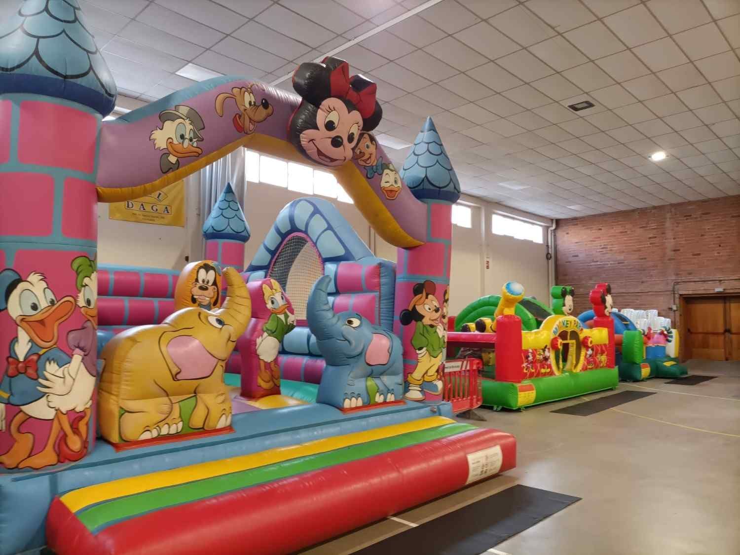 Zona de juegos hinchable interior llena de color con personajes de Disney, como Mickey, Donald.