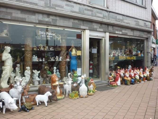 Winkelpui met rijen keramische dieren- en kabouterbeeldjes die buiten de winkel tentoongesteld staan.