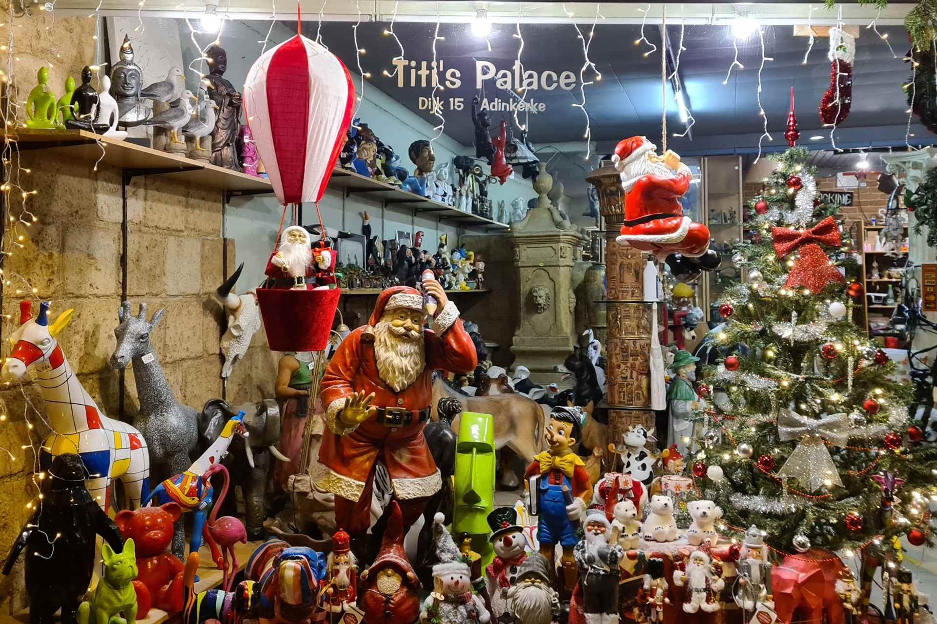 Feestelijke kerstetalage met kerstmannetjes, versieringen en een versierde kerstboom.