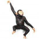 Zwarte chimpanseefiguur met één arm omhoog, zittend op een witte achtergrond.