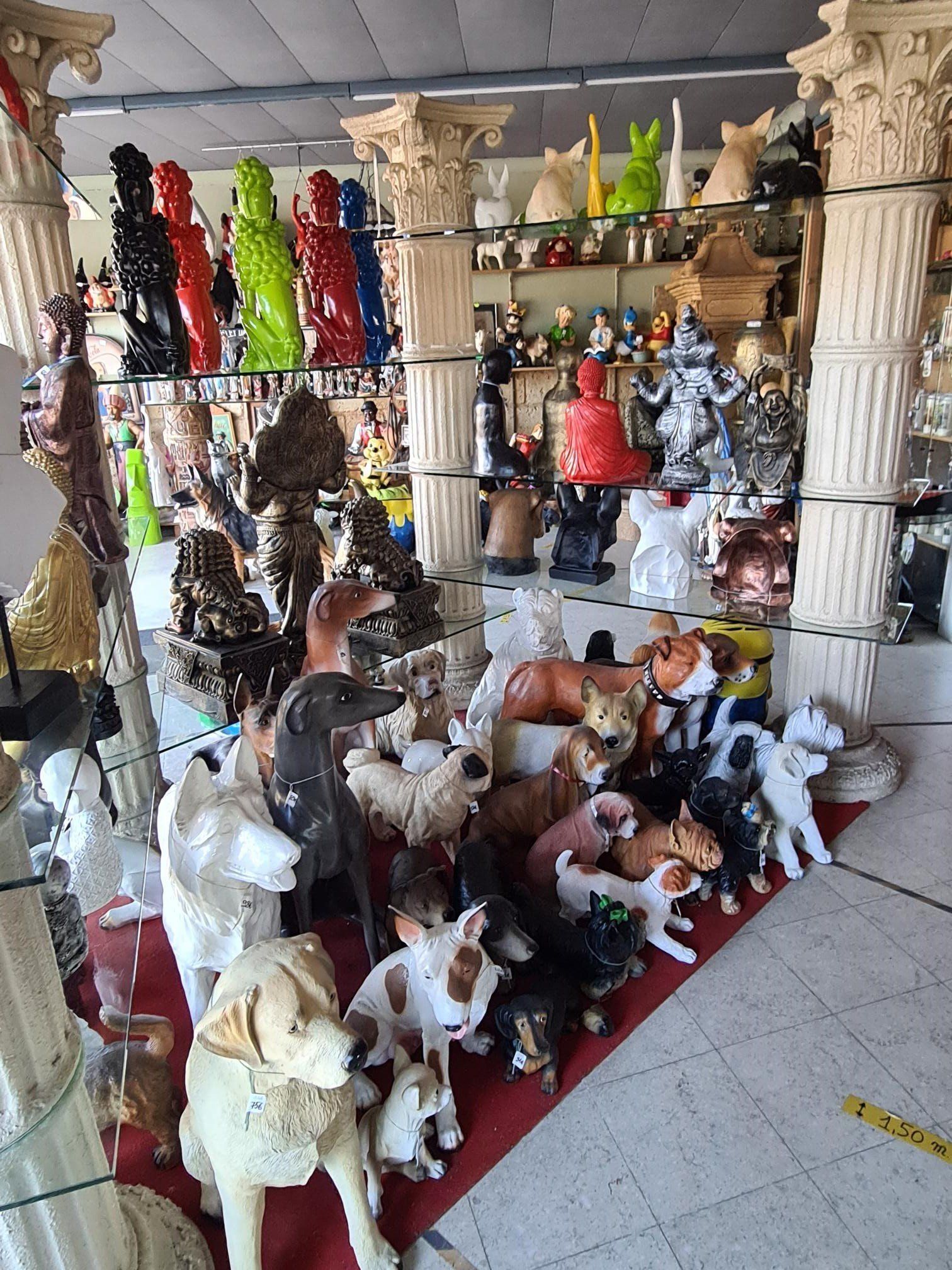 Diverse decoratieve dierenbeeldjes en kleurrijke hangende ornamenten tentoongesteld in een winkel of marktkraam.