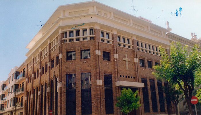 Un gran edificio de ladrillo con una cruz en el costado.