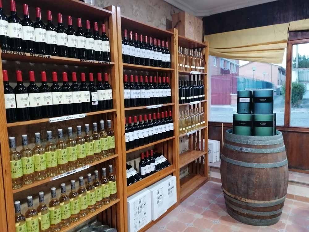 Estantes llenos de botellas de vino y un barril de madera.