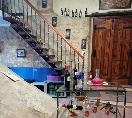 Una habitación con escaleras y botellas de vino en una mesa.