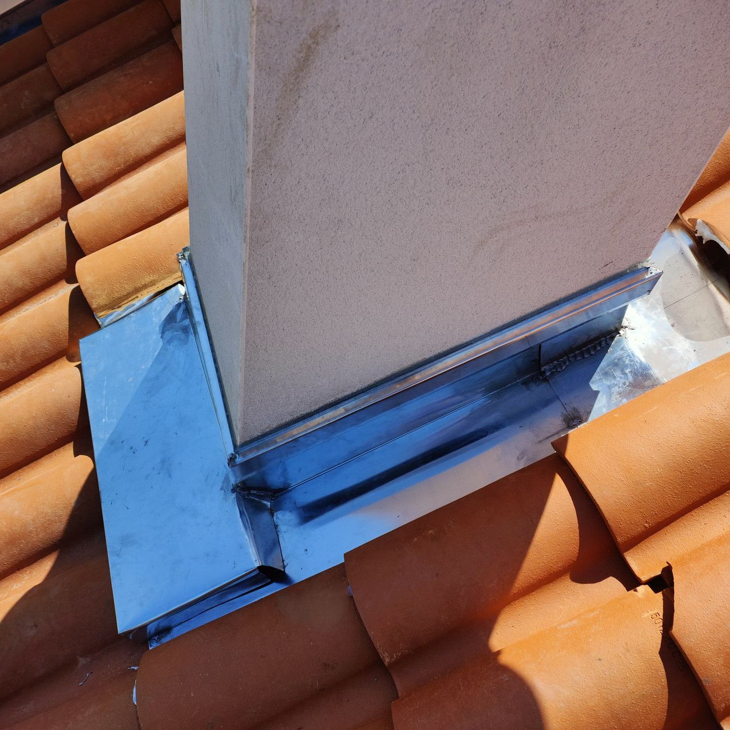 Solin de cheminée sur un toit en tuiles