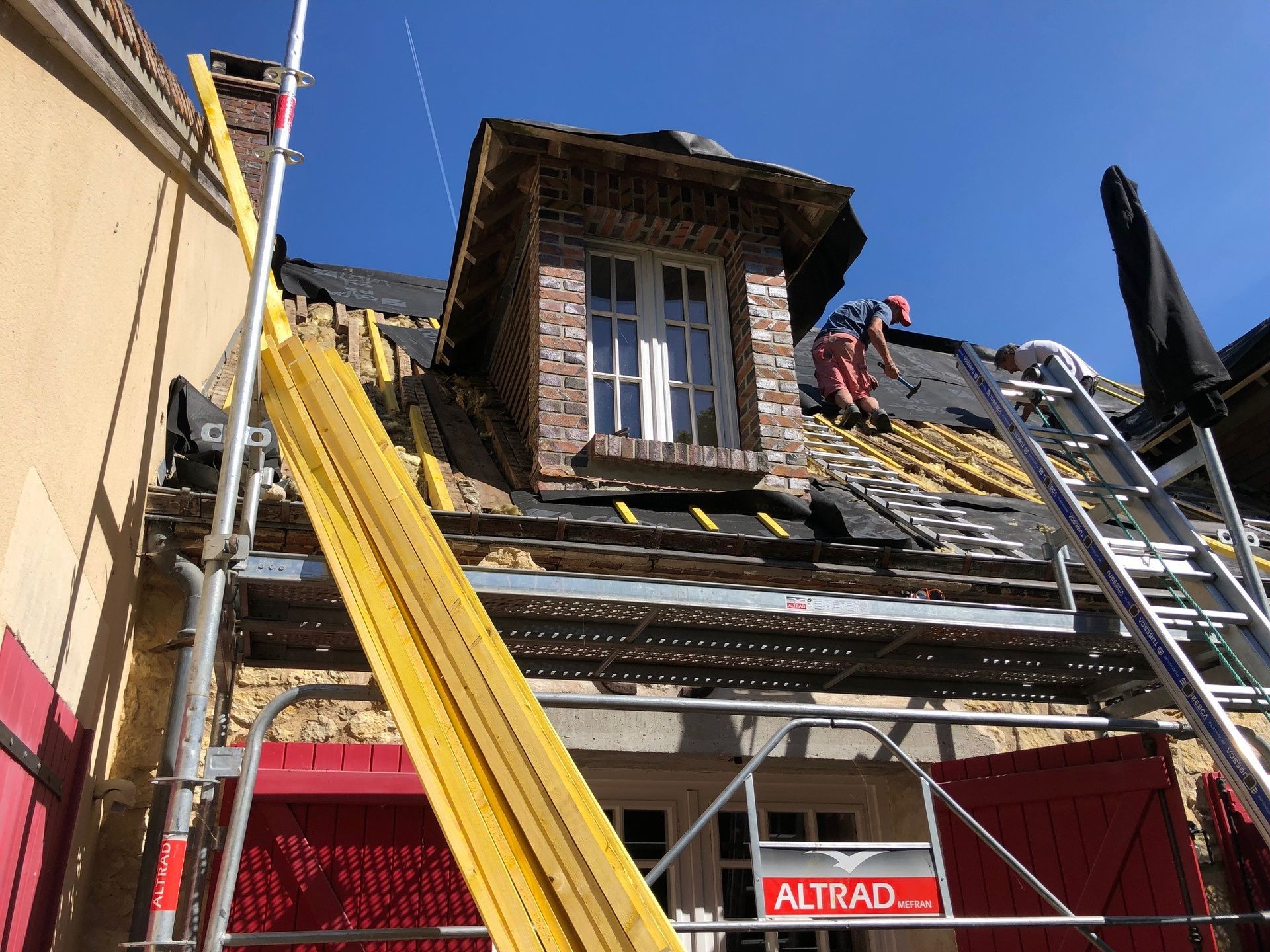 Couvreur installant des tuiles sur des chevrons en bois
