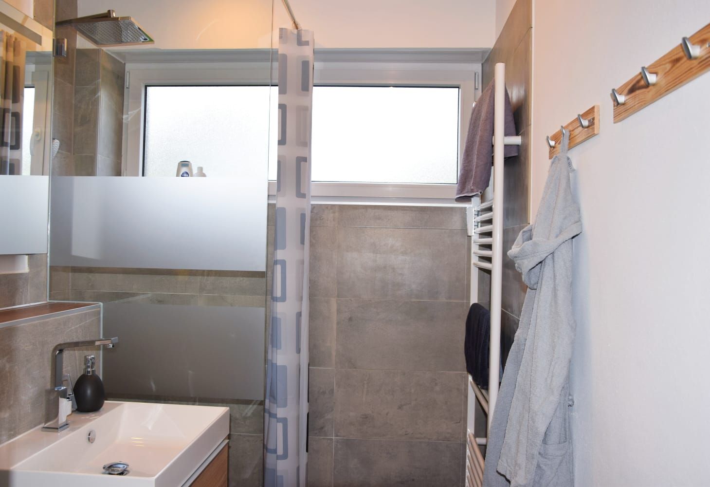 Badezimmer mit Dusche, Waschbecken und Handtuchheizung in der Ferienwohnung in Schönwald im Schwarzwald