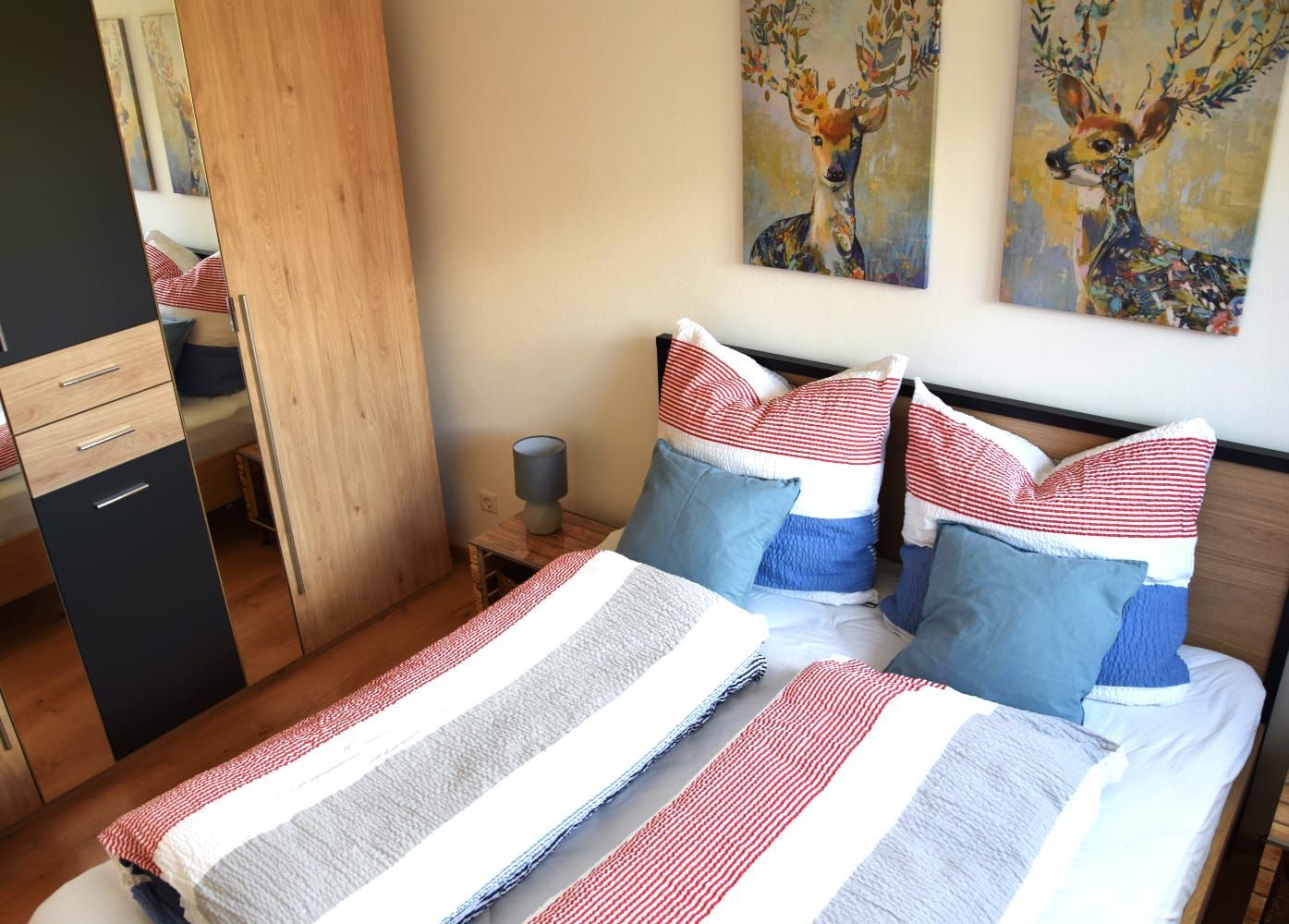 Schlafzimmer mit Doppelbett, Kleiderschrank und Hirschbildern in der Ferienwohnung in Schönwald im Schwarzwald