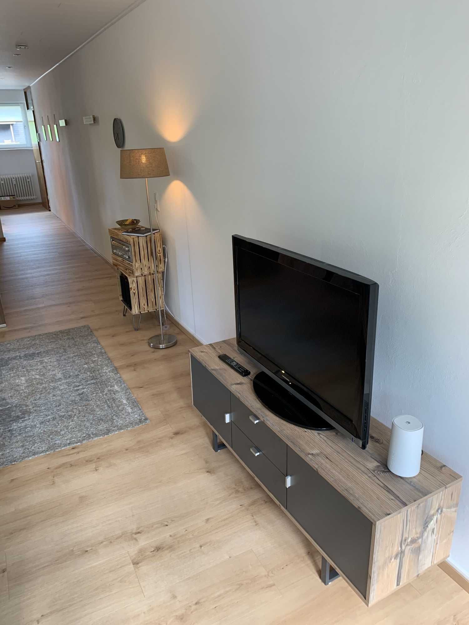 Wohnzimmer mit Fernseher, Sideboard und gemütlicher Beleuchtung in der Ferienwohnung in Schönwald im Schwarzwald