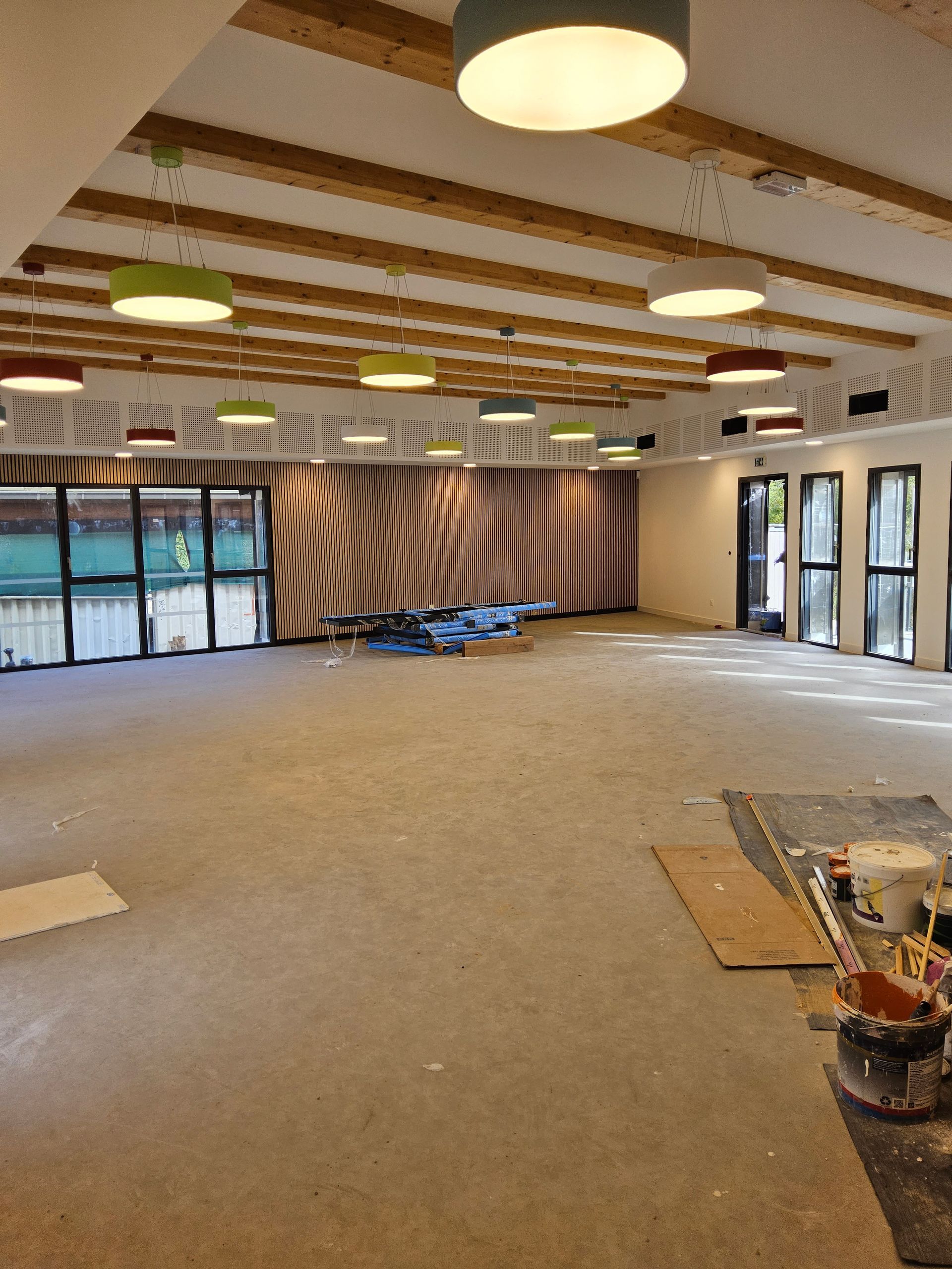 Construction d'une grande pièce ; structure du plafond, murs et éclairage apparents ; vue intérieure.