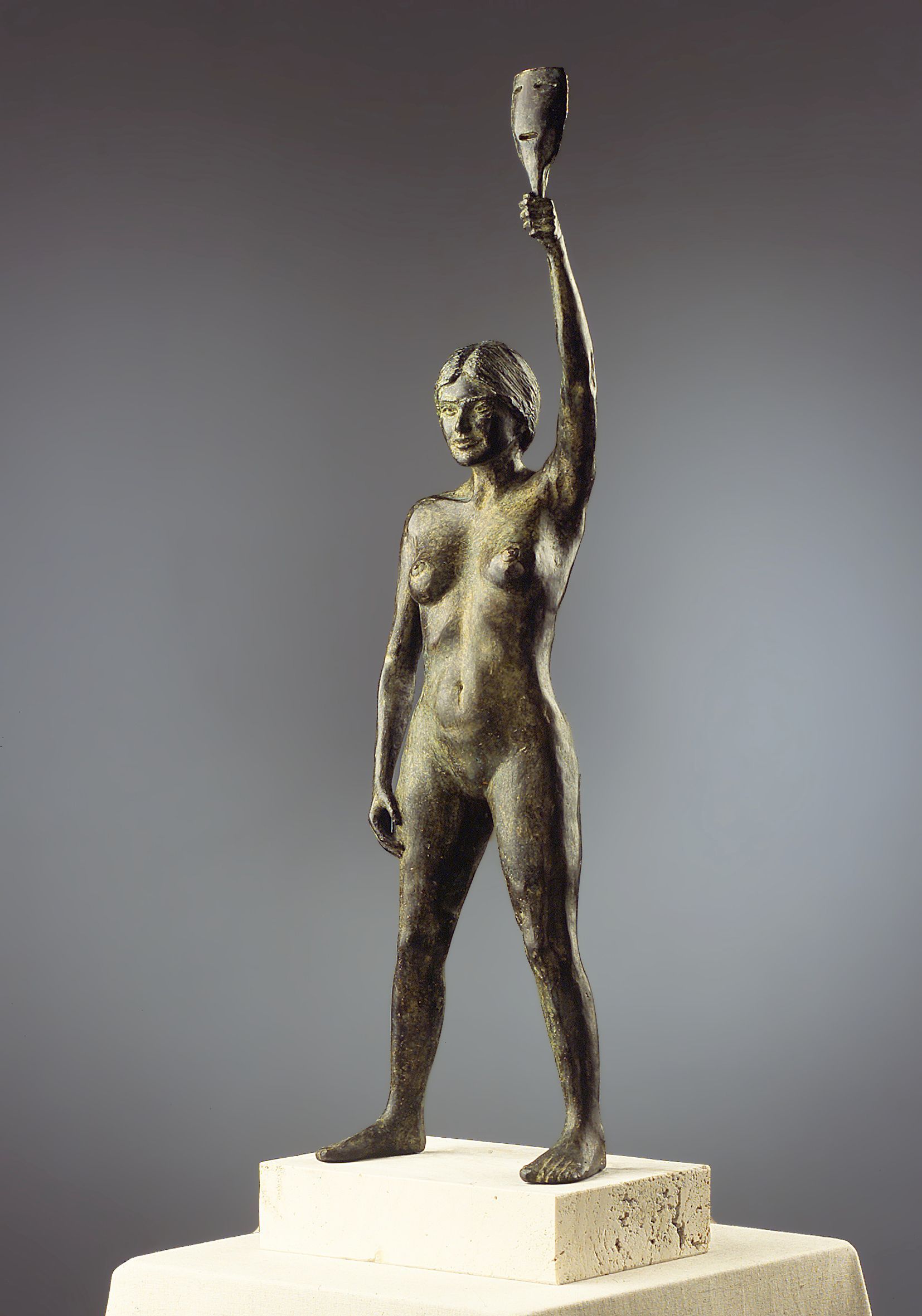 Una estatua de bronce de una mujer que sostiene una antorcha en su mano.