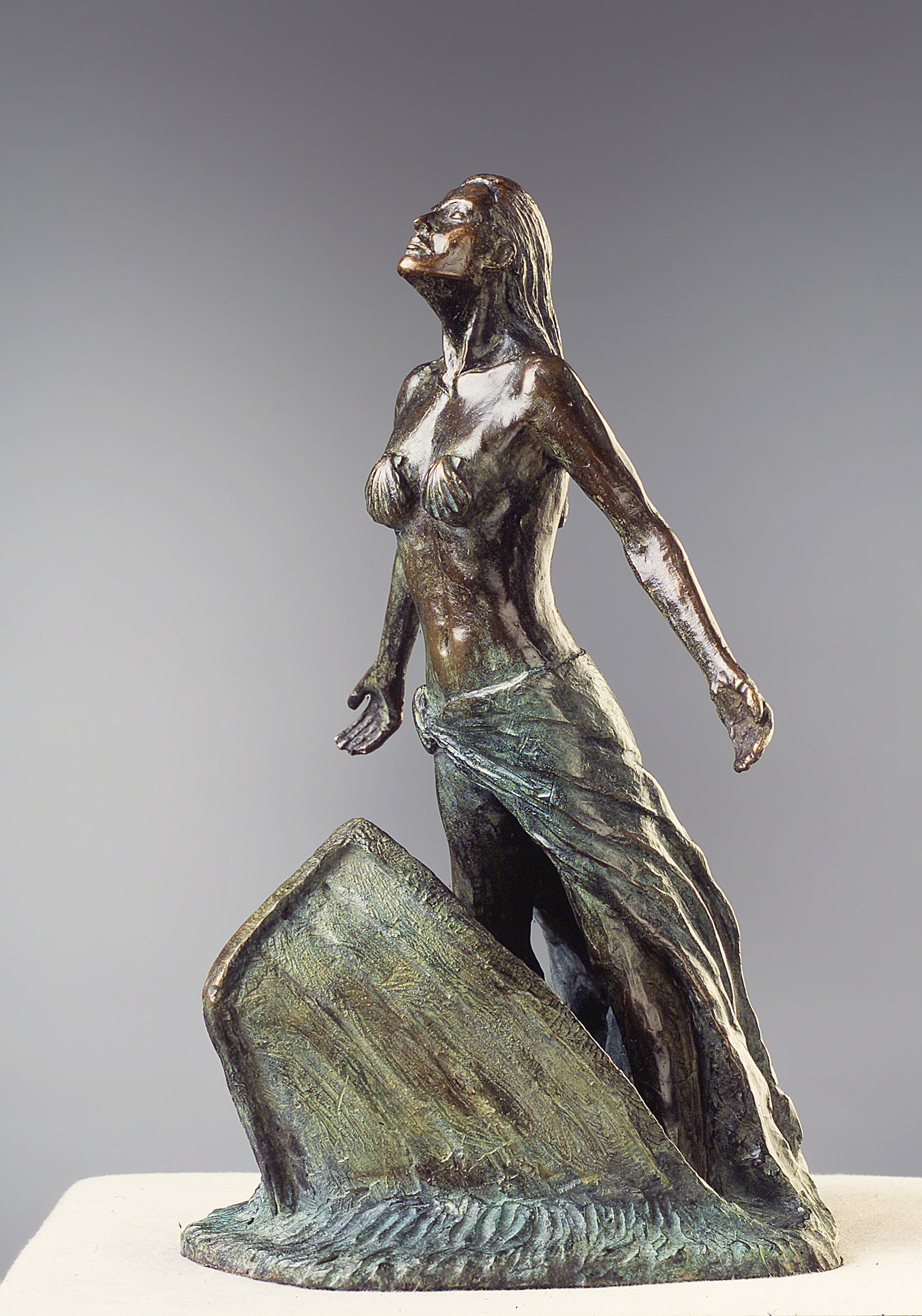 Una estatua de bronce de una mujer con los brazos extendidos