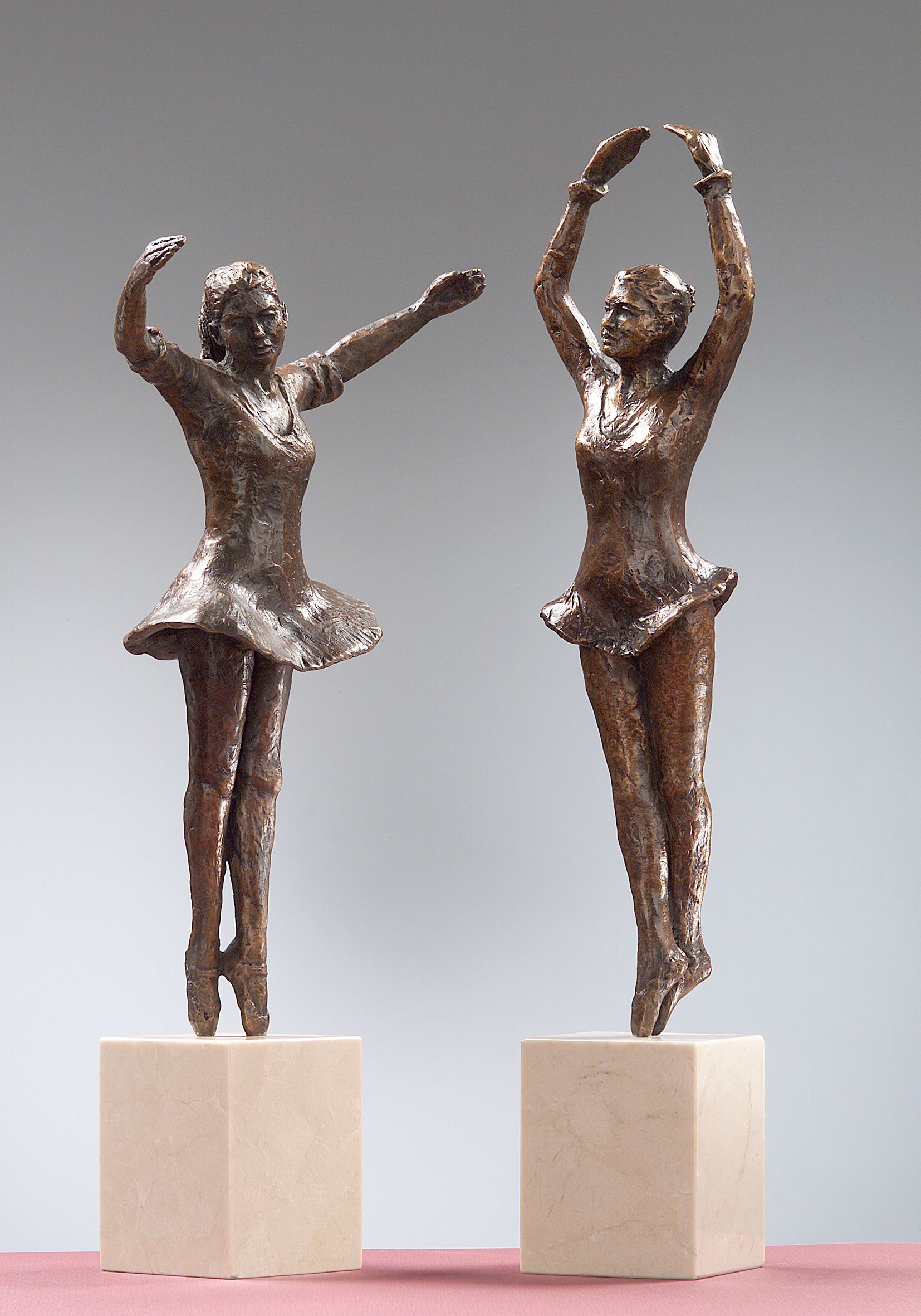 Dos estatuas de bronce de bailarinas están una al lado de la otra.