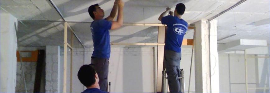 Dos hombres con camisas azules están trabajando en un techo.