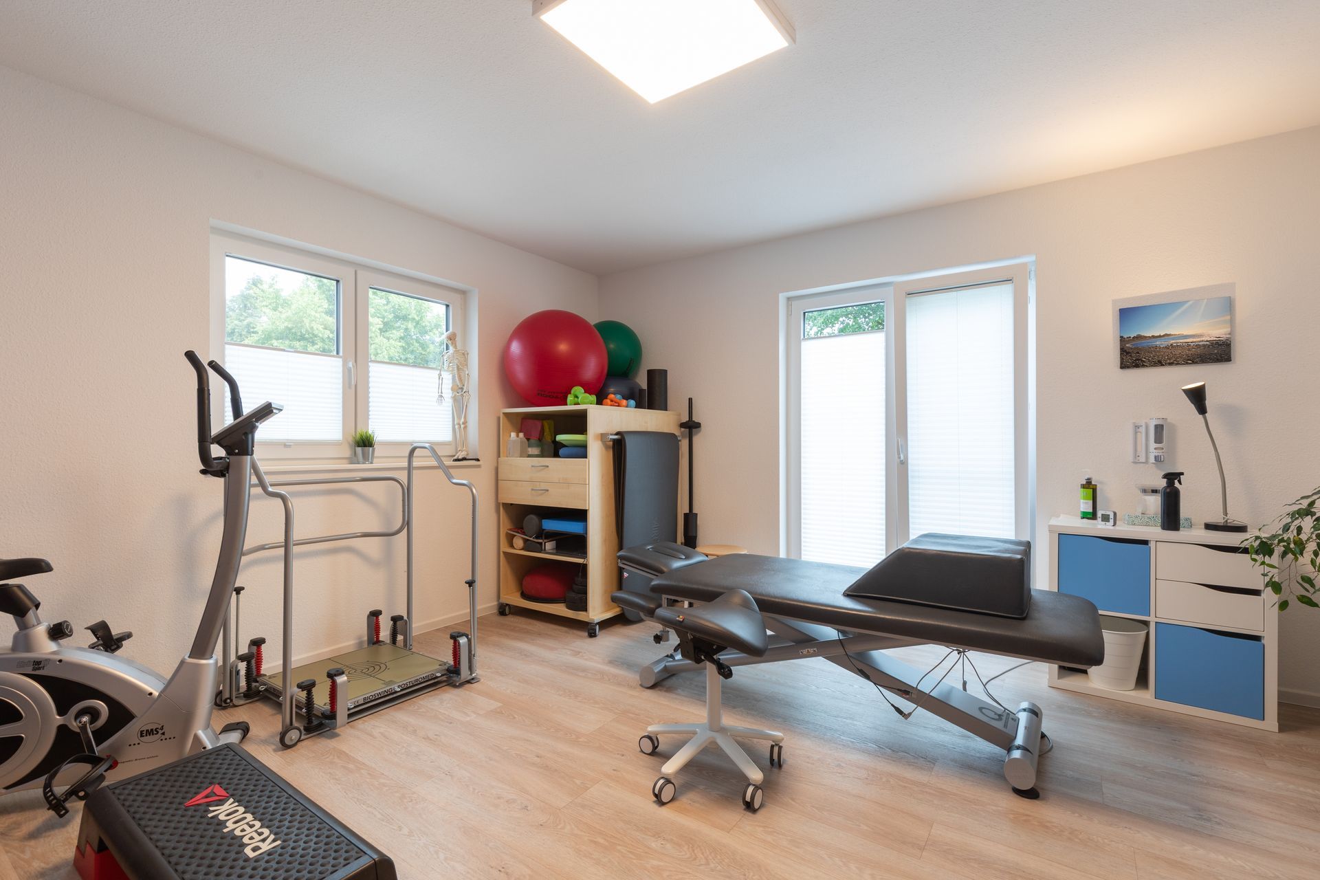 Ein Zimmer mit Bett, Heimtrainer, Gymnastikball und anderen Trainingsgeräten.