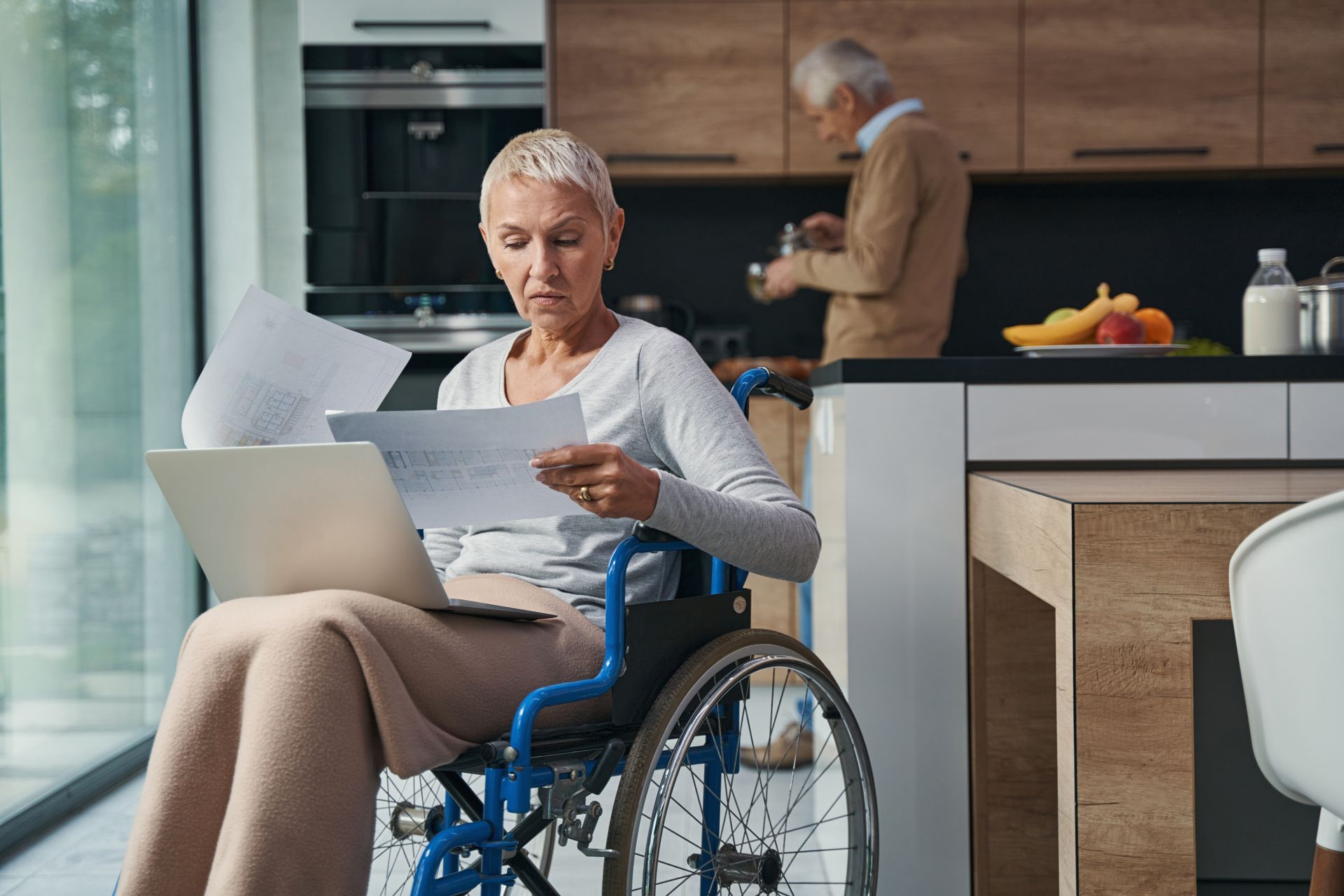 Une femme en fauteuil roulant en train de regarder des documents