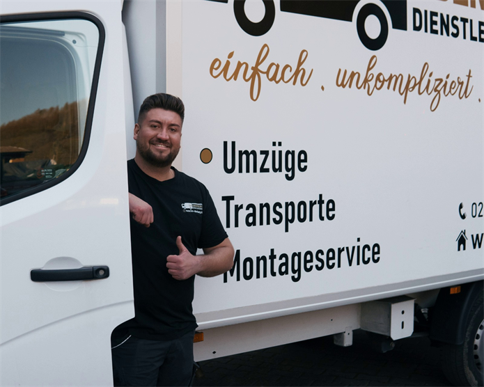 Ein Mann lehnt an einem weißen LKW mit der Aufschrift „Umzüge Transporte Montageservice“
