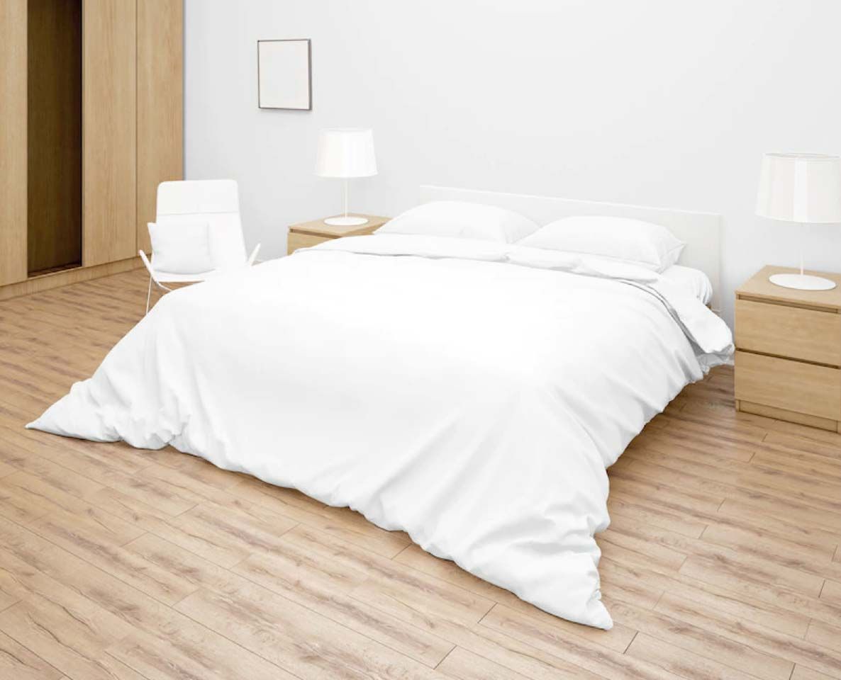 Un dormitorio minimalista con una cama blanca, mesitas de noche con lámparas y suelos de madera.