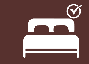Icono de cama con una marca de verificación, que probablemente indica que hay una habitación con cama disponible.