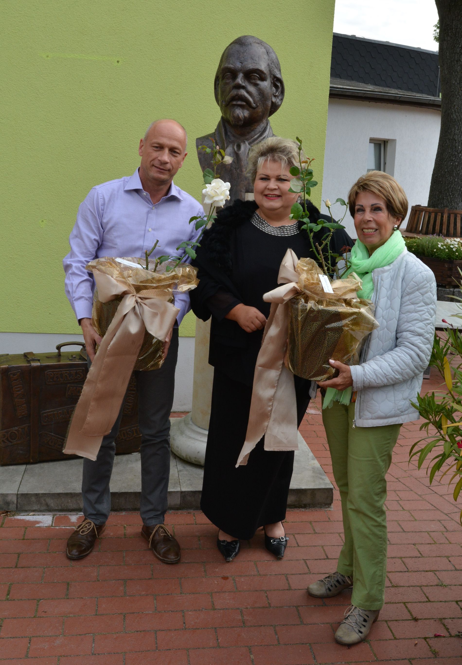 drei Personen vor Statue