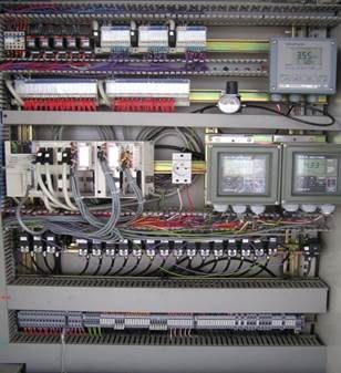 Panneau de commande avec fils, bornes et affichages, probablement destiné à des équipements industriels.