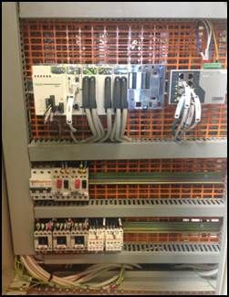 Panneau de contrôle électrique avec divers composants et câblage.