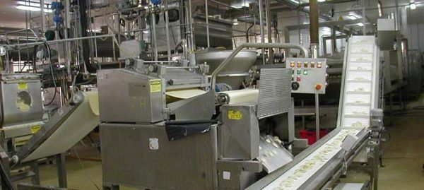 Machines industrielles de transformation des aliments dans une usine, déplaçant la pâte.