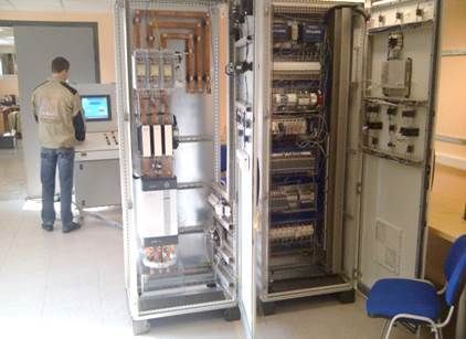 Homme travaillant sur un panneau de contrôle avec une armoire électrique ouverte.