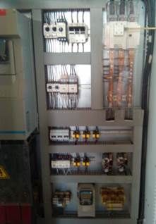 Panneau de contrôle électrique avec divers composants, câblage et disjoncteurs.