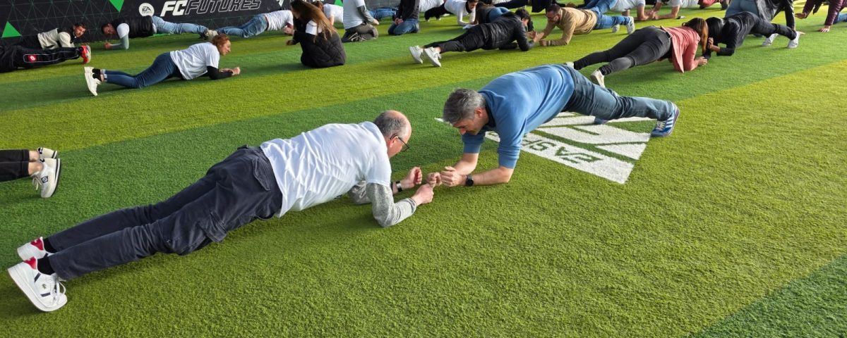 Des gens font des planches sur du gazon artificiel.