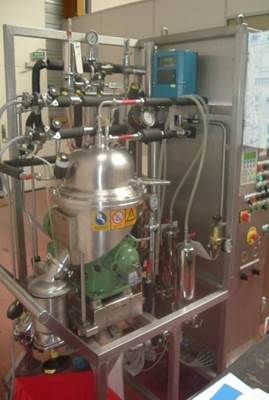 Séparateur industriel en acier inoxydable avec divers tuyaux, jauges et panneau de commande.