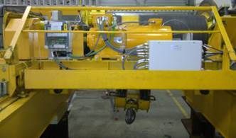 Grue industrielle jaune avec machines, y compris un crochet, à l'intérieur.