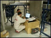 Deux personnes en blouse de laboratoire travaillant sur un ordinateur, probablement sur une analyse de données, dans un laboratoire.