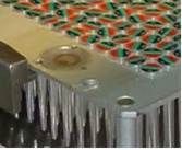 Gros plan d'un composant métallique avec de nombreux petits objets circulaires colorés et des broches métalliques.