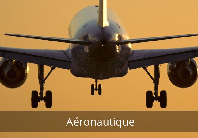 Avion atterrissant sur fond de coucher de soleil orange ; étiquette "Aéronautique".